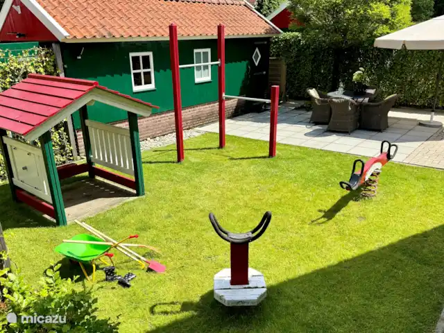 Aan de voorzijde van de woning zijn diverse speeltoestellen in eigen tuin.